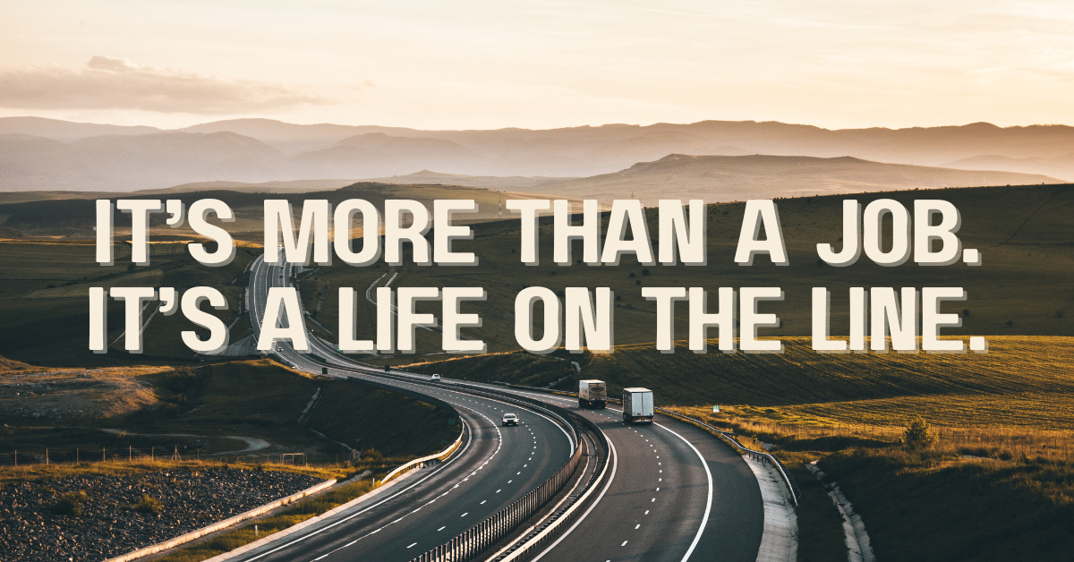 A lone highway curves through open fields at sunset, two trucks traveling side by side. Text overlay reads: "It’s More Than a Job. It’s a Life on the Line."