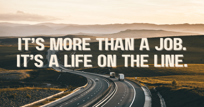 A lone highway curves through open fields at sunset, two trucks traveling side by side. Text overlay reads: "It’s More Than a Job. It’s a Life on the Line."