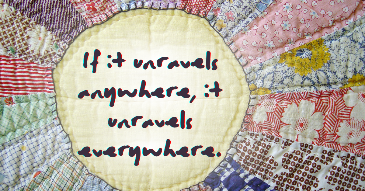 Hand-stitched quilt with floral and patterned fabric pieces, centered with the words ‘If it unravels anywhere, it unravels everywhere,’ symbolizing fragile heritage and unity.