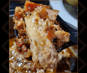 Close-up of tender slow-cooked pork lifted from a Dutch oven, showing juicy meat and rich, seasoned sauce.