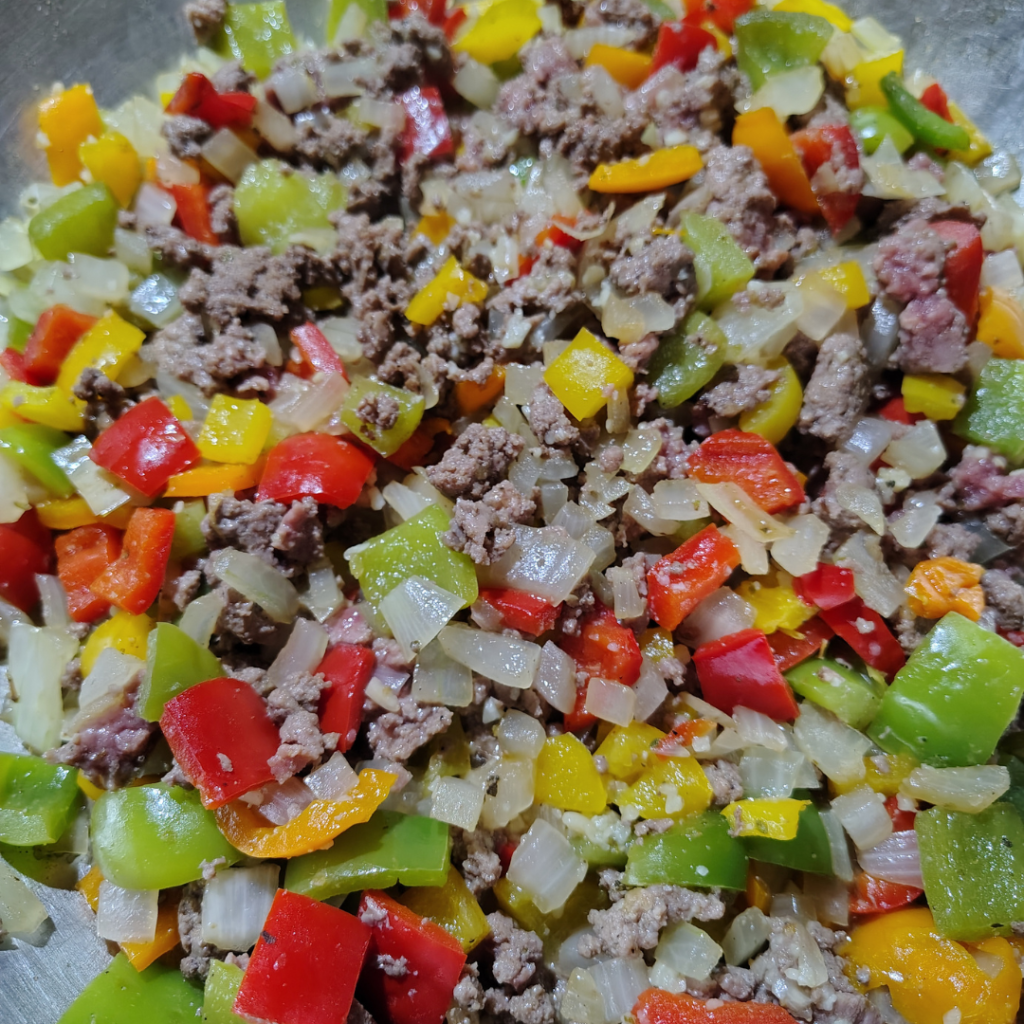 Colorful bell peppers, onion, garlic, and extra-lean ground beef cooking together in the rescued stainless steel wok as the base for Dirty Cabbage in the Rescued Wok.