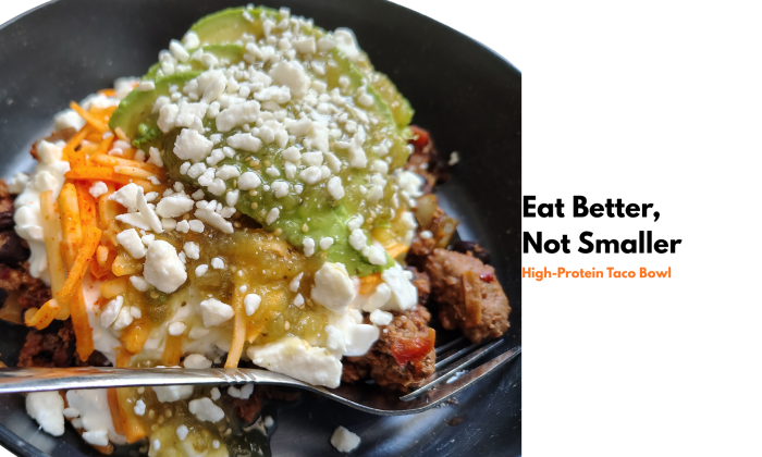Feature image for a high-protein taco bowl post showing a bowl topped with avocado, salsa verde, cottage cheese, shredded cheese, and feta, with overlay text reading “Eat Better, Not Smaller: High-Protein Taco Bowl.”