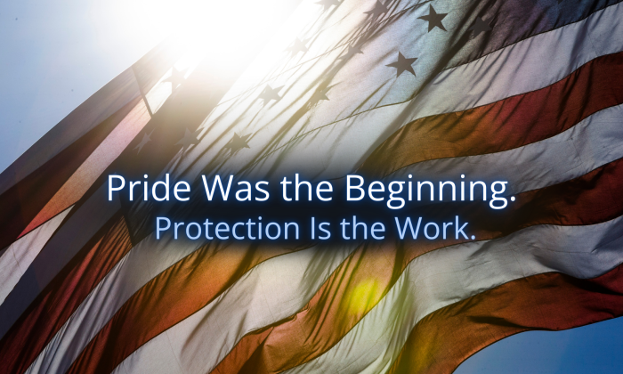 American flag waving in sunlight with the words “Pride Was the Beginning. Protection Is the Work.” centered in soft blue text.