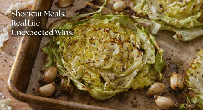 Roasted cabbage steaks with caramelized edges and whole garlic cloves on a baking sheet, overlaid with the words “Shortcut Meals. Real Life. Unexpected Wins.”