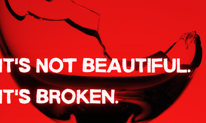 A close-up of a shattered wine glass against a bold red background. The jagged break runs sharply through the rim, symbolizing damage and danger. Overlaid in bold white text are the words: “IT’S NOT BEAUTIFUL. IT’S BROKEN.”