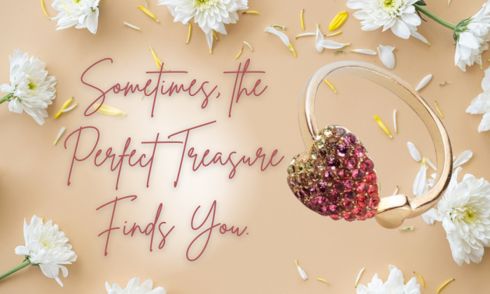 A gold ring with a heart-shaped cluster of pink and golden rhinestones is displayed against a soft beige background scattered with white daisies and yellow flower petals. Elegant cursive text reads, “Sometimes, the Perfect Treasure Finds You.